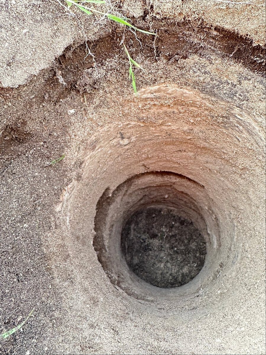Close-up of completed soil bore in sandy soil profile